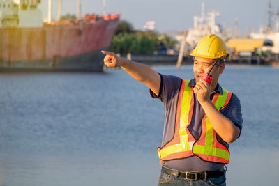 Midsection of man standing by sea