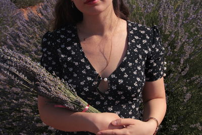 Midsection of woman holding flowering plant