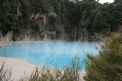 Scenic view of hot spring against mountain