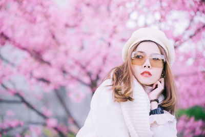 Beautiful woman standing against pink flower