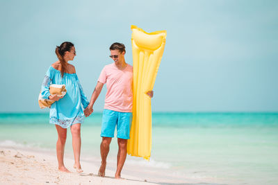 People standing on beach against sky