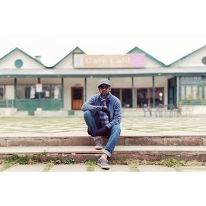 Full length portrait of young man on house against building