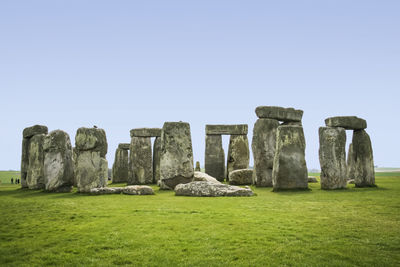 Stone wall on field against clear sky