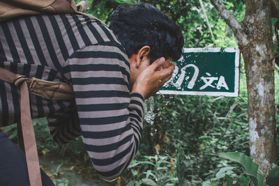 Low section of man with text on sign