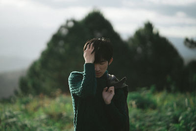 Young man standing against mountains