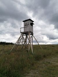 Traditional windmill on field against sky