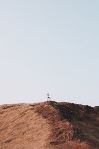 Man on dirt road against clear sky