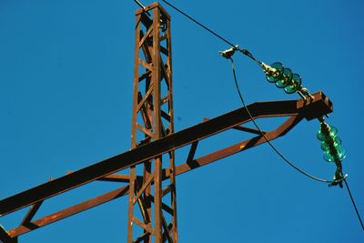 Low angle view of chain swing ride against clear blue sky