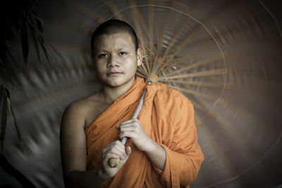 Portrait of monk holding umbrella