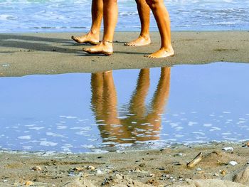 Low section of people standing on beach