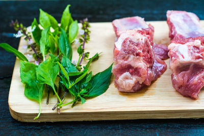 Raw meat and leaves on cutting board