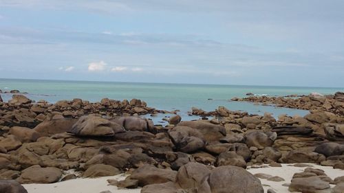 Rocks on beach against sky