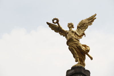 Low angle view of angel statue against sky