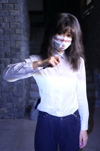 Side view of young woman standing against wall