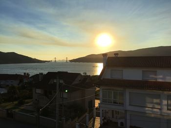 High angle view of buildings by sea against sky during sunset