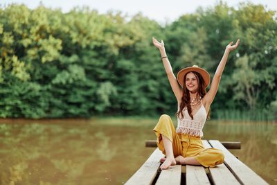 Portrait of young woman sitting on pier