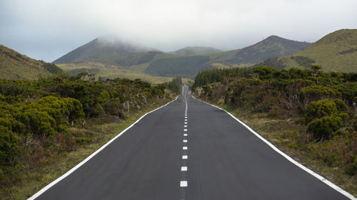 Empty road leading towards mountains