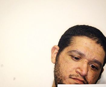 Close-up portrait of man wearing hat against white background