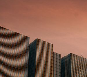 Low angle view of modern buildings against sky during sunset