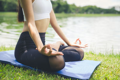 Midsection of woman sitting on grass