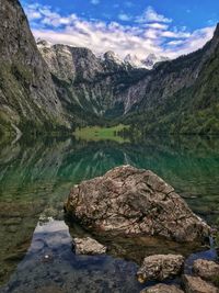 Scenic view of lake by mountains against sky