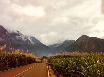 Road by mountains against sky