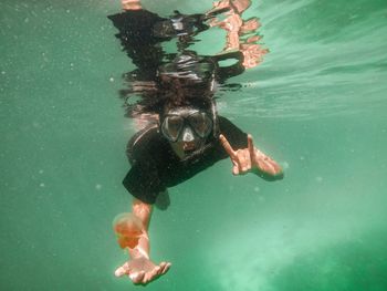 Man swimming in sea with jellyfish