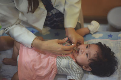 Midsection of doctor examining baby girl