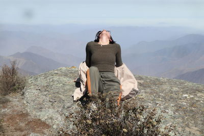 Rear view of man sitting on mountain