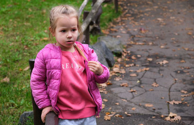 Portrait of cute girl blowing bubbles on field