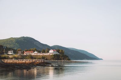 Scenic view of sea and buildings against clear sky