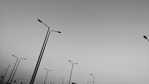 Low angle view of silhouette birds flying against clear sky