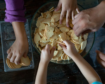 Kids making kek batik or malaysian triple chocolate dessert. crushing the cookies into tiny pieces