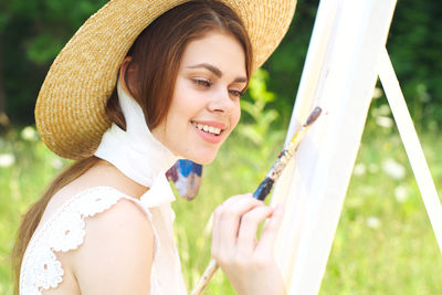 Young woman wearing hat standing outdoors