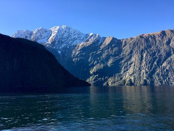 Scenic view of snowcapped mountains against clear blue sky