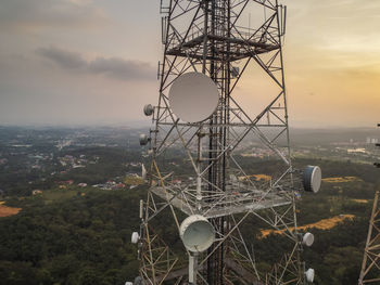 Low angle view of communications tower against sky during sunset