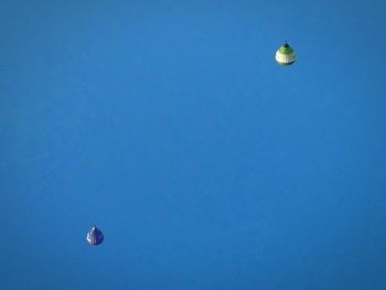 Low angle view of hot air balloons against blue sky