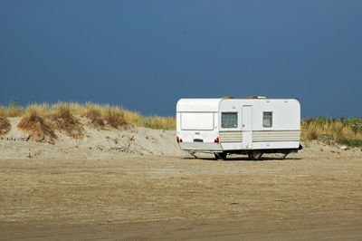 Roulotte on a beach against clear sky