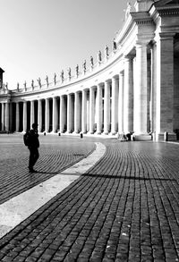Rear view of man walking on street in city