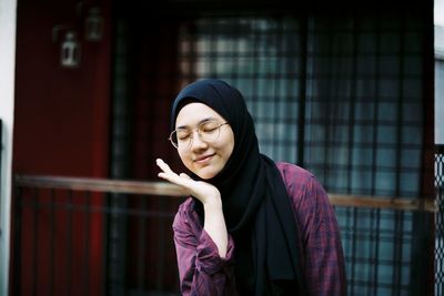 Teenage girl wearing hijab and eyeglasses with closed eyes