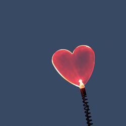 Low angle view of heart shape against blue sky