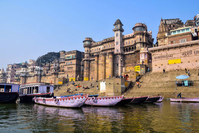 Boats in river with buildings in background