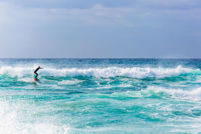 Man surfing in sea against sky