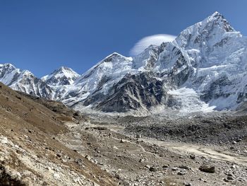 Scenic view of snowcapped mountains against blue sky