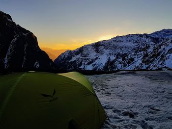 Scenic view of snowcapped mountains against sky during sunset