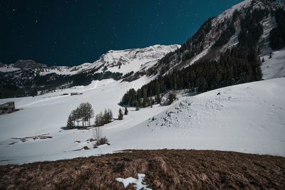 Scenic view of snowcapped mountains against sky at night