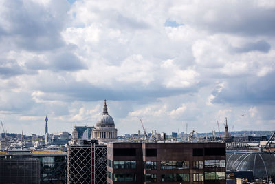 Buildings in city against cloudy sky