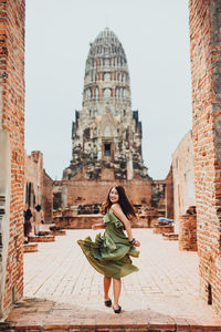 Tourist woman in green dress at wat ratchaburana temple, ayutthaya, thailand