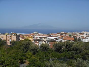 High angle view of buildings against clear blue sky