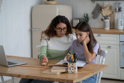 Young woman using laptop at table